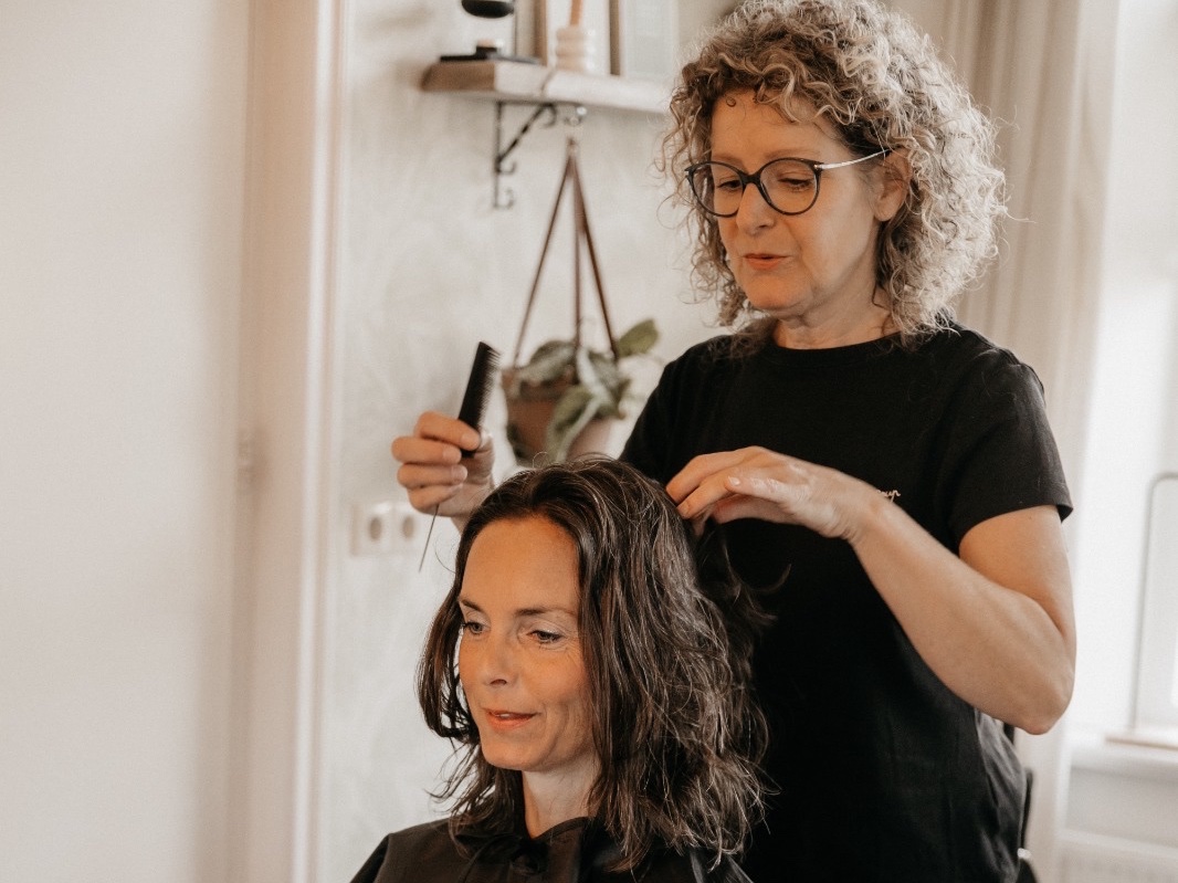 Vrouw met krullen lacht na de knipbeurt